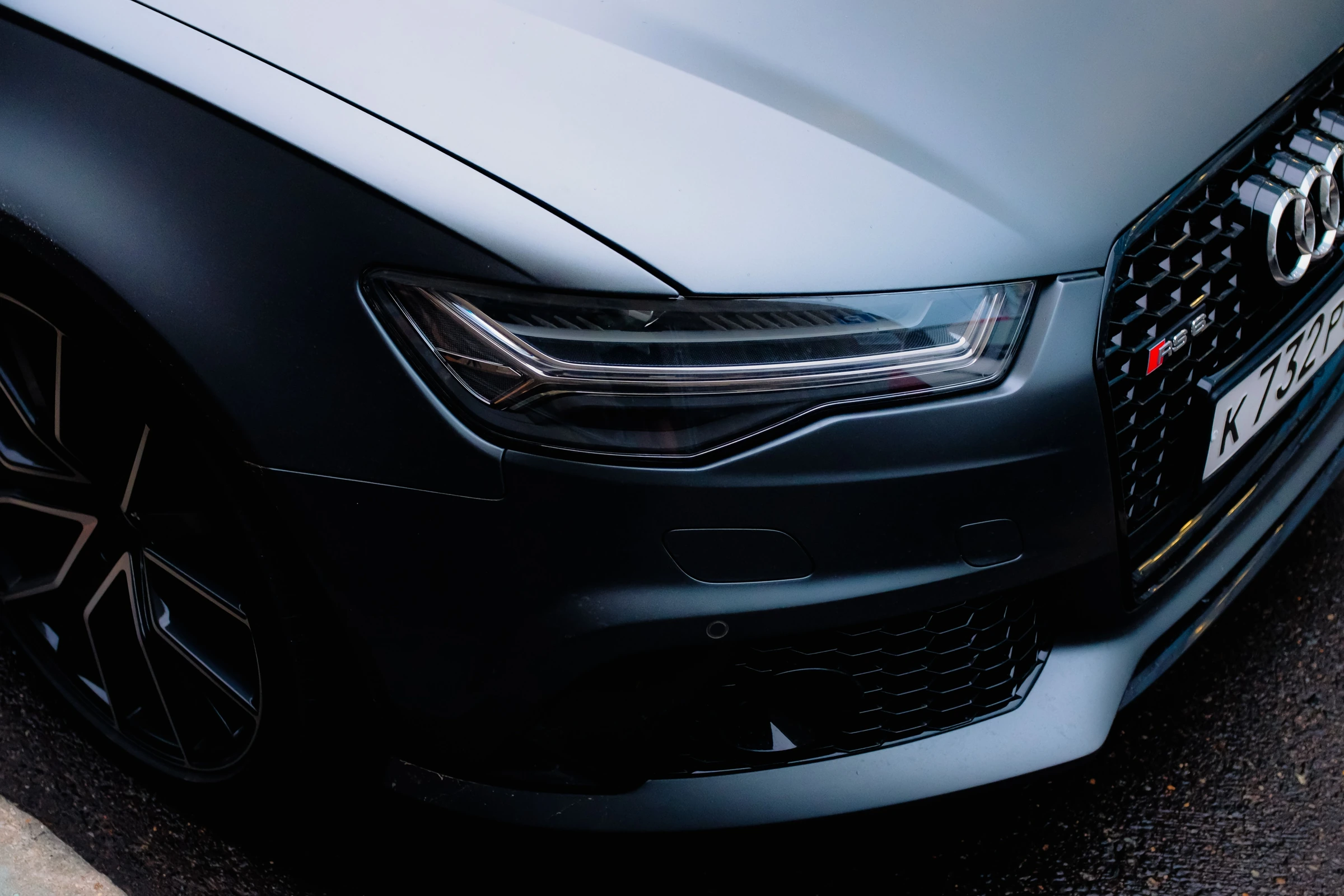 Detailed view of a metallic silver Audi RS6 headlight and front end, photographed by Vova Kras